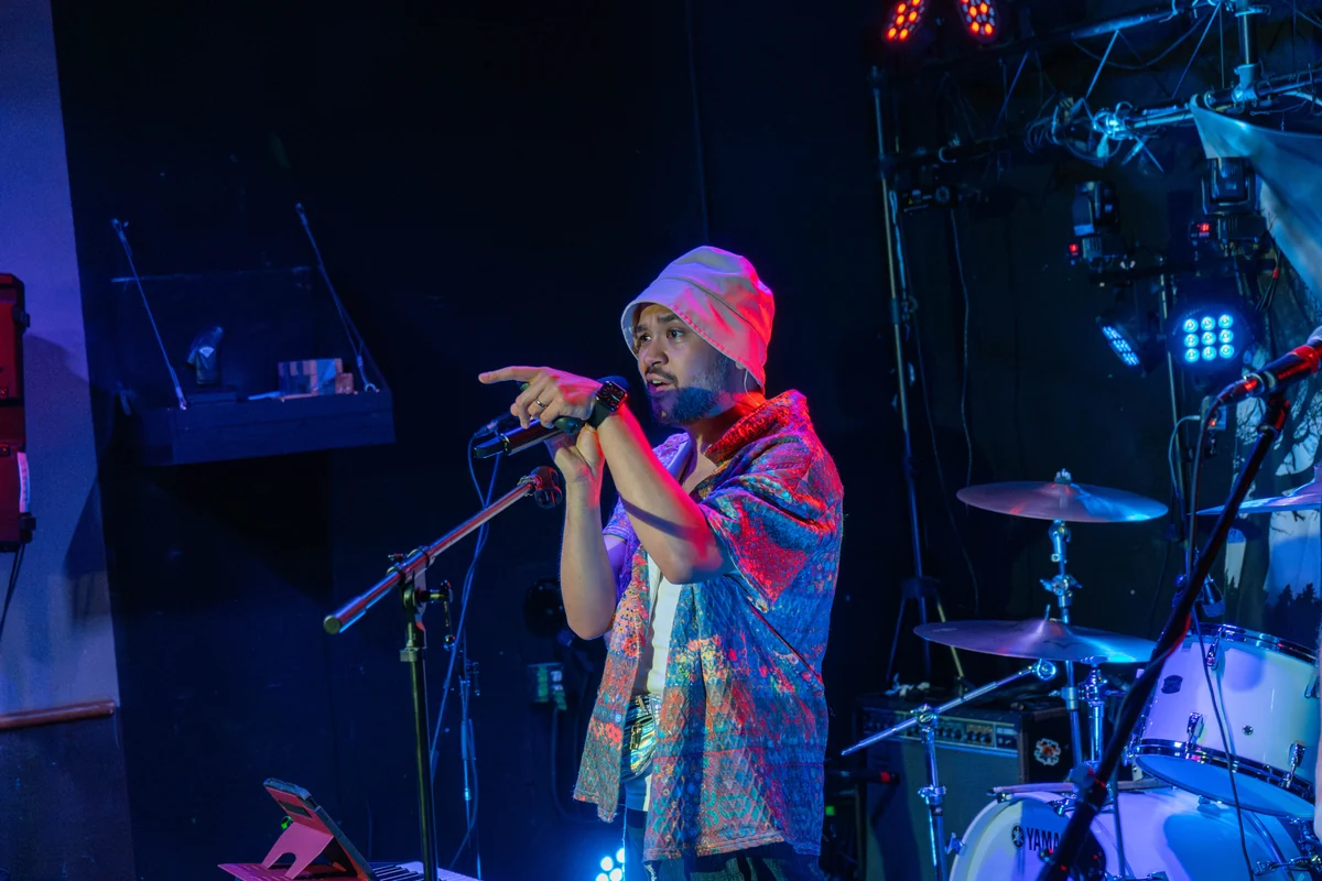 NotMuch's vocalist pointing toward the audience under blue stage lights at The Wolf